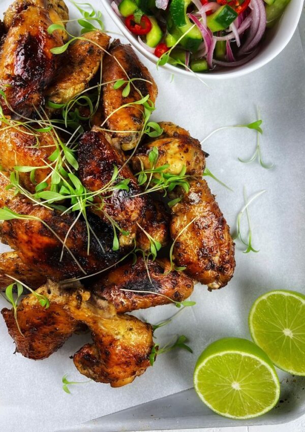 Chicken wings on a tray with lime wedges