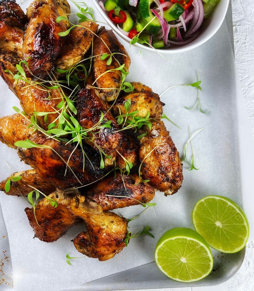 Chicken wings on a tray with lime wedges