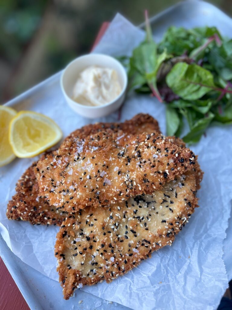 crispy chicken on tray with mayonnaise, lemon and salad leaves