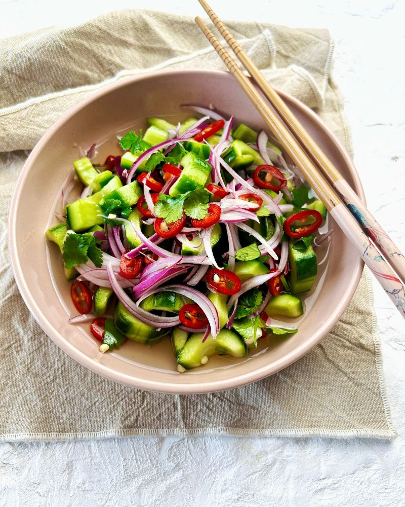 Quick Pickled Asian cucumbers in bowl with napkin underneath and chopsticks