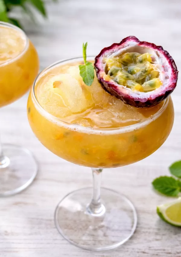frozen cocktail in a glass on white timber board.
