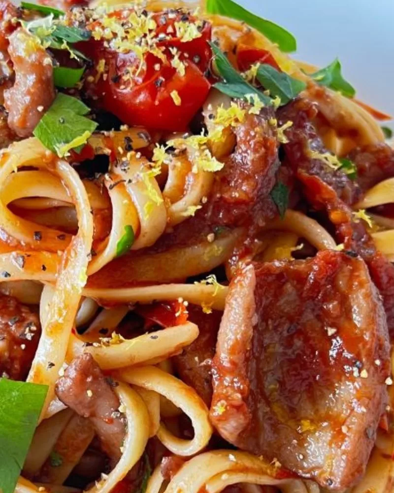 Close-up of tender slow-cooked squid in tomato and chilli pasta sauce