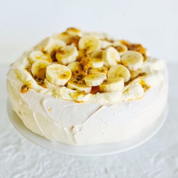 Best Pavlova topped with cream, banana and passionfruit