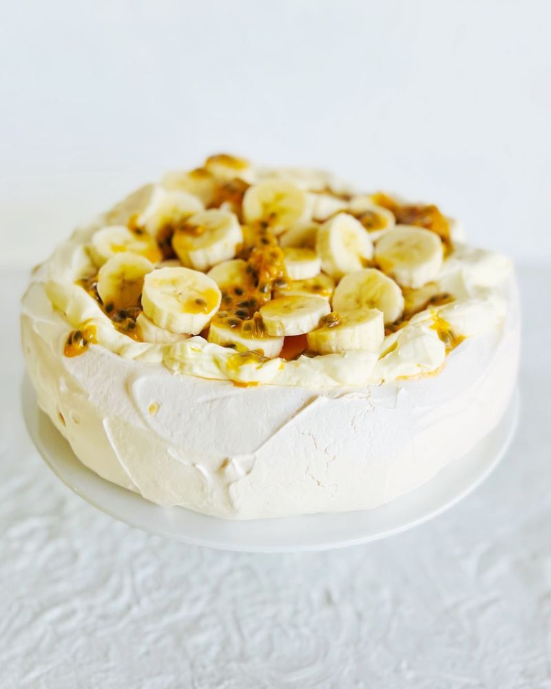 Best Pavlova topped with cream, banana and passionfruit