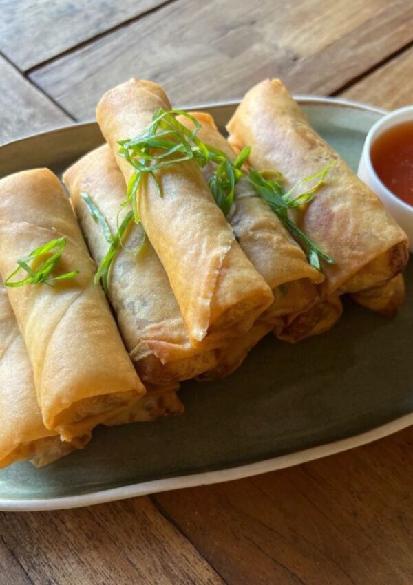 spring rolls on a plate with sweet and sour sauce in a bowl