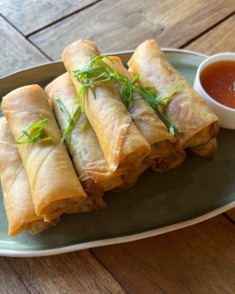 spring rolls on a plate with Chinese sweet & sour sauce in a bowl