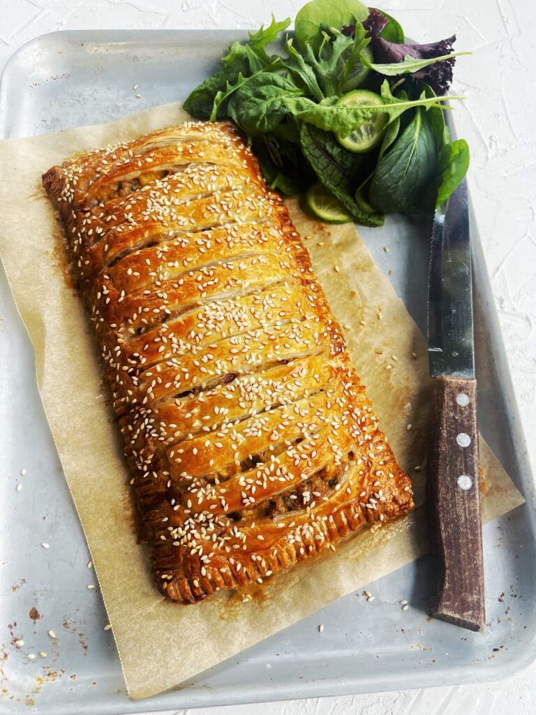 Tuna & Corn Jalousie on baking tray with knife and salad leaves