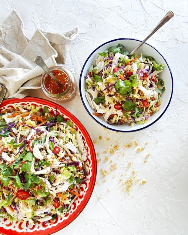 Vietnamese Chicken Salad in 2 bowls with jar of dressing