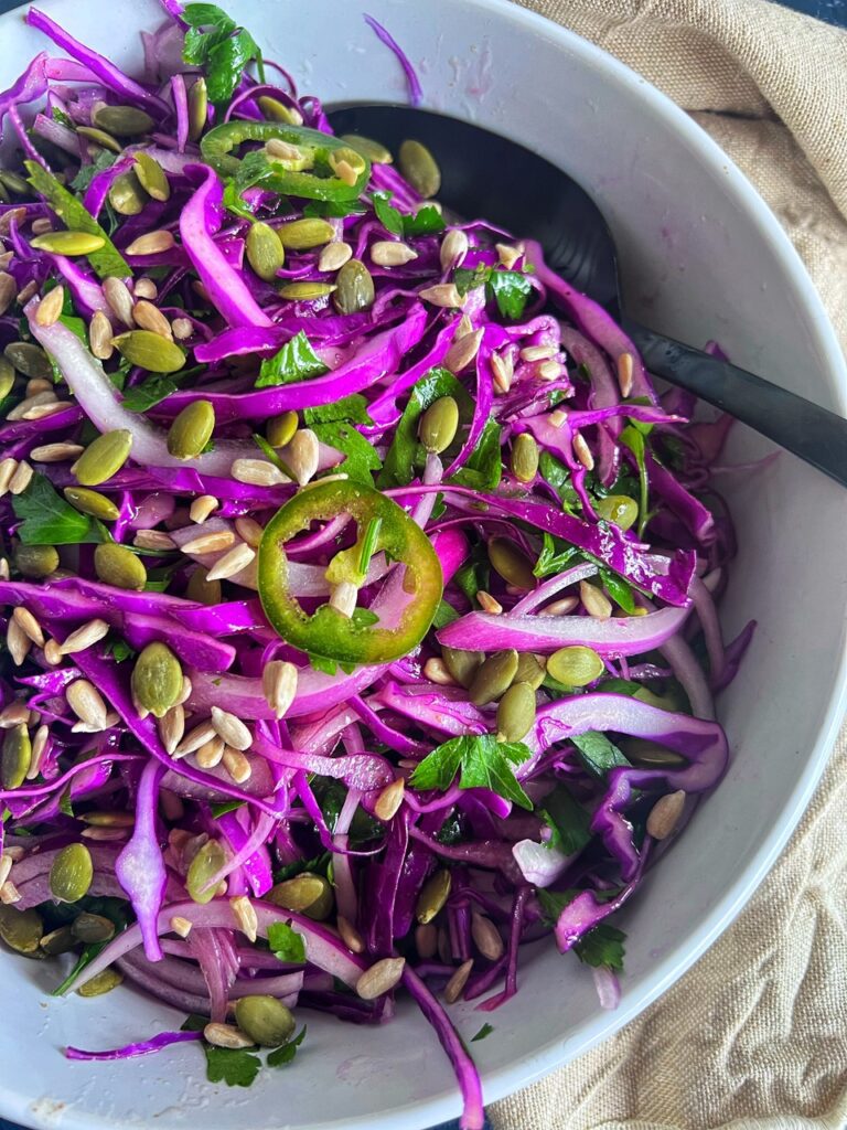 Close up image of Red cabbage salad in bowl with a serving spoon