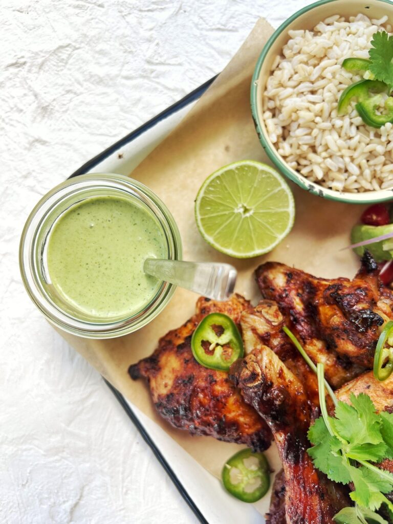 green sauce on a tray with chicken and rice