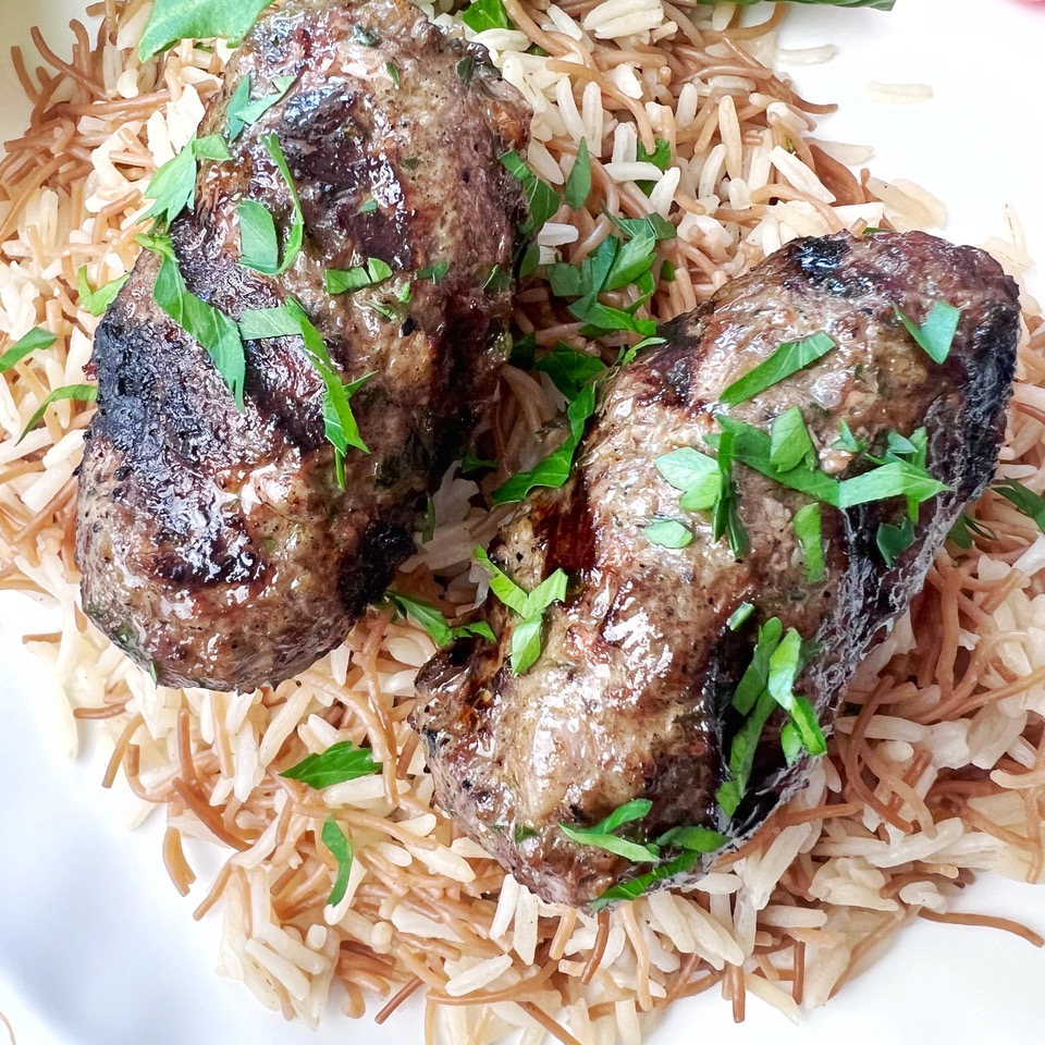 lamb kafta on Lebanese rice with chopped parsley.