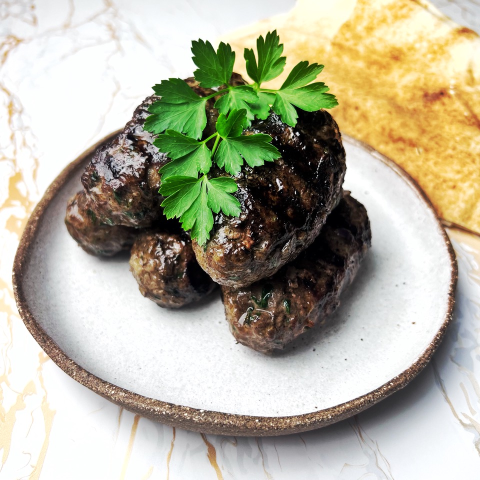 Lamb Koftas stacked on a plate with parsley