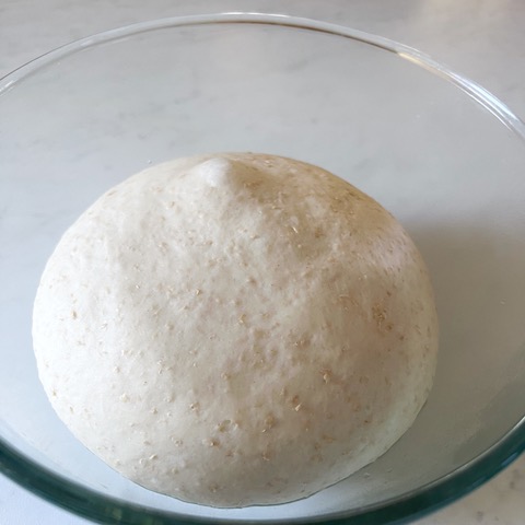 Pita bread dough in a bowl after rising