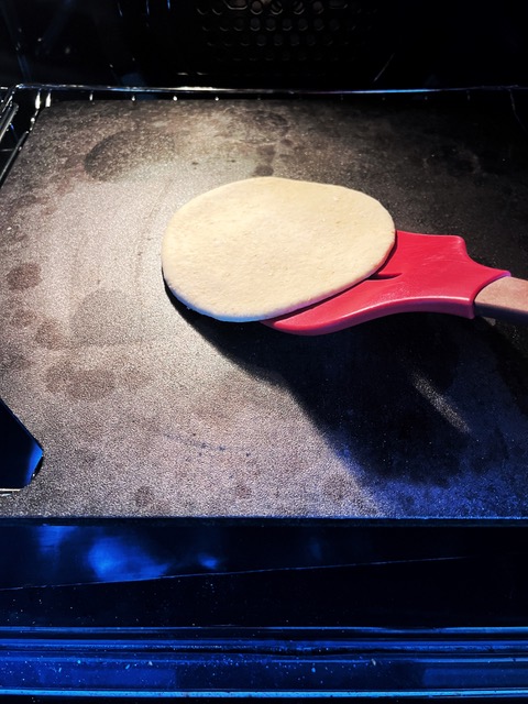 Pita bread going into the oven onto a baking steel
