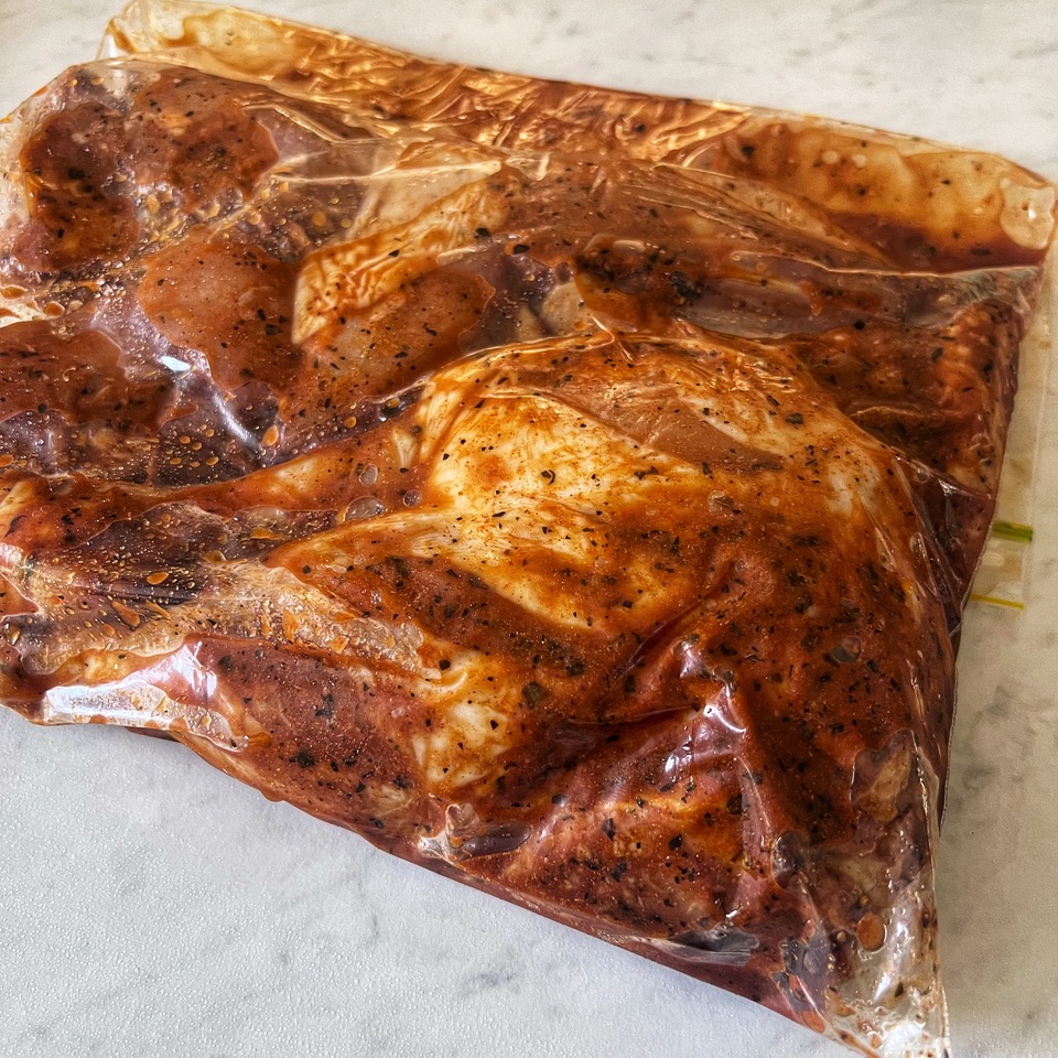 chicken pieces marinating in a zip-lock bag