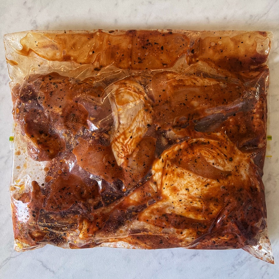 chicken pieces marinating in a zip-lock bag
