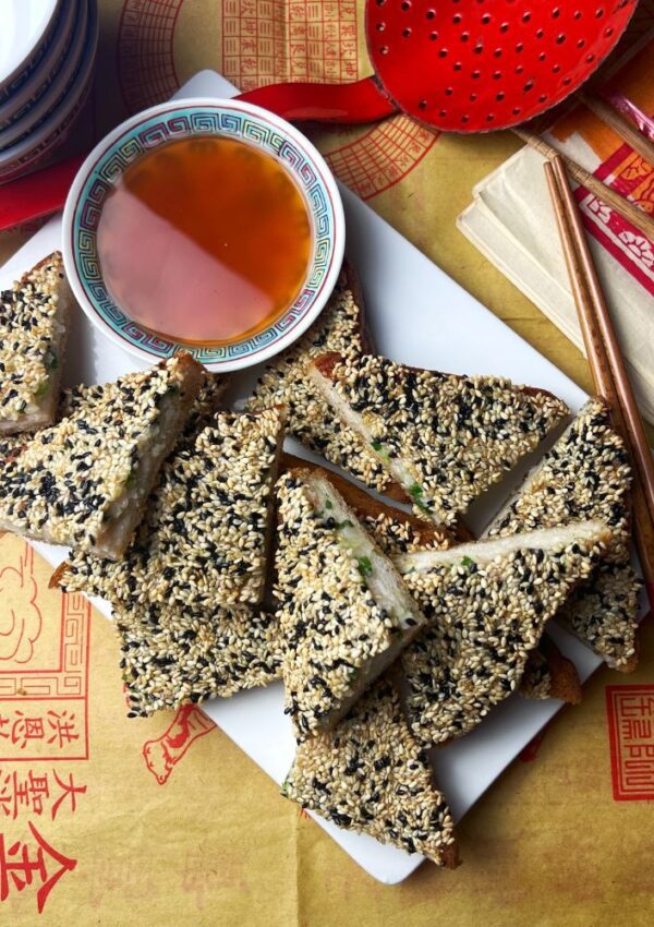 Prawn Toast on Chinese style paper with sweet and sour sauce in bowl