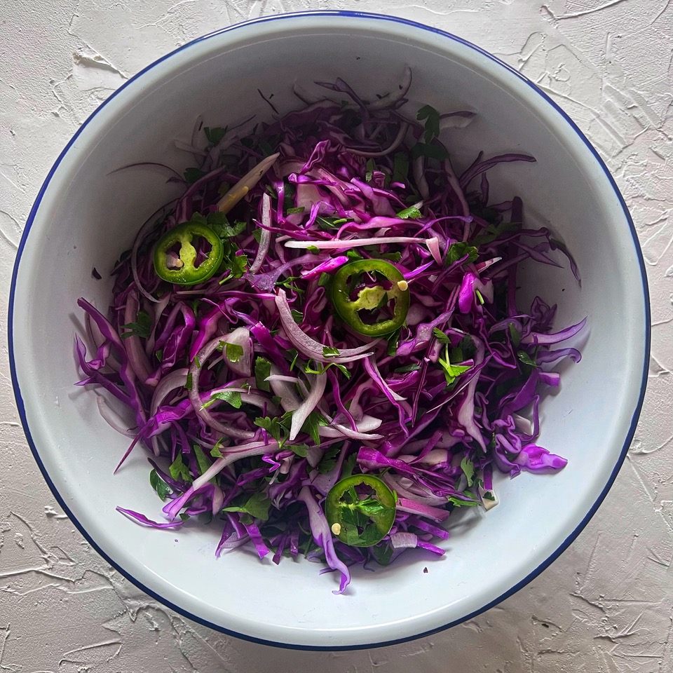 Slaw ingredients in a bowl tossed together