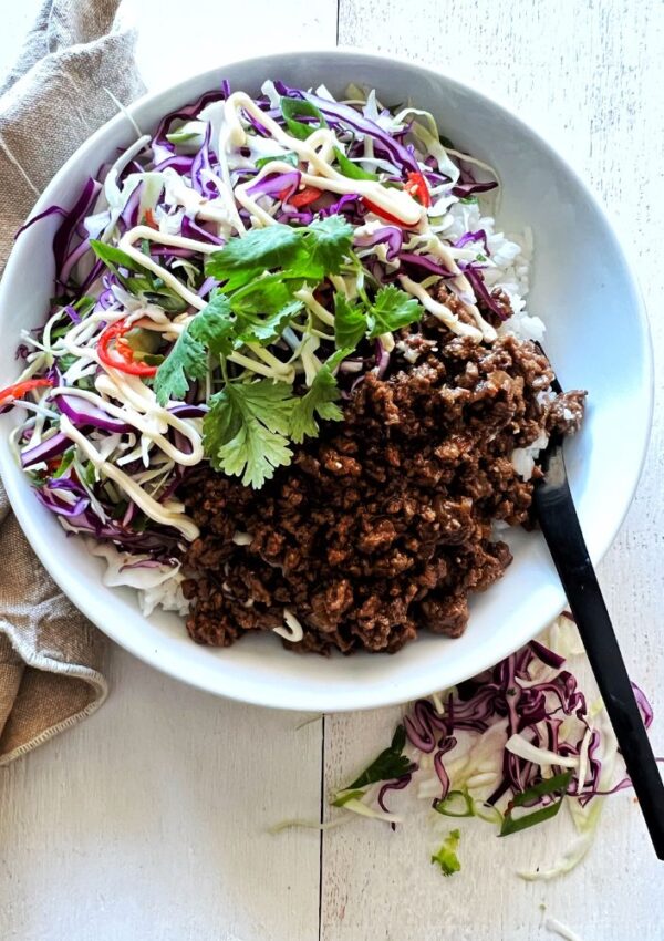 Asian beef mince in white bowl with slaw on white background