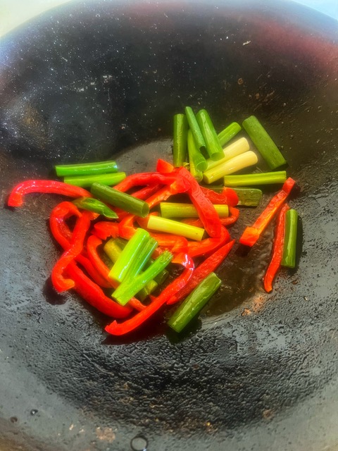 capsicum and green onion cooking in wok
