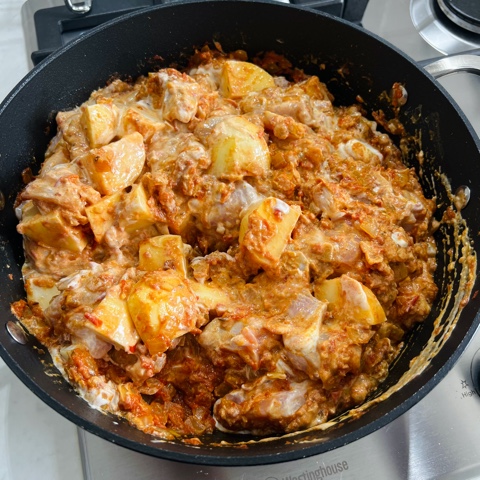 onion mixture in a pan with potatoes, chicken and yoghurt stirred through