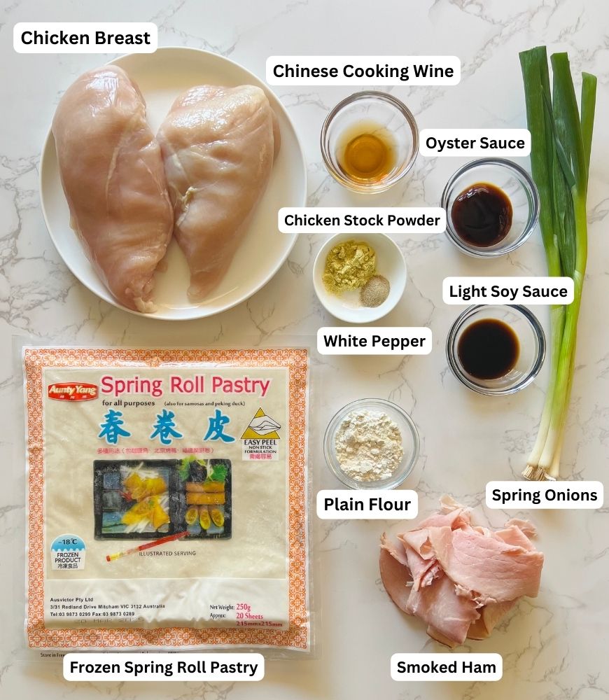 Chicken & Ham Spring Roll Ingredients laid out on marble board. 
Chicken breast, shaoxing wine, oyster sauce, chicken stock powder, ground white pepper, soy sauce, plain flour, smoked ham and spring roll wrappers