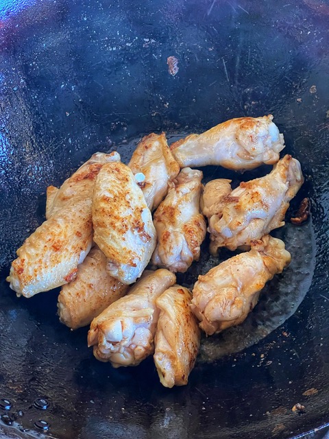 chicken wings browning in wok