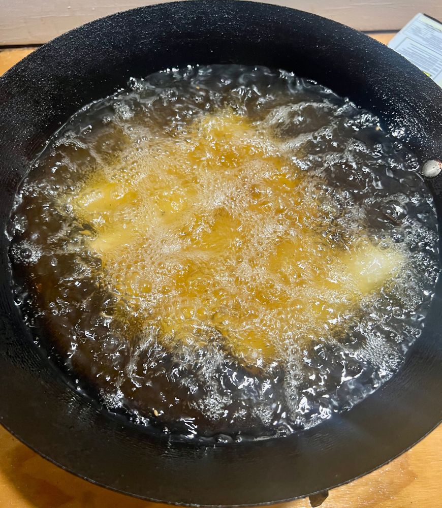 Deep frying spring rolls in a wok