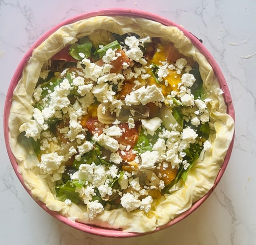 ROASTED VEGETABLE QUICHE FILLING IN FILLO LINED TIN WITH FETA OVER THE TOP