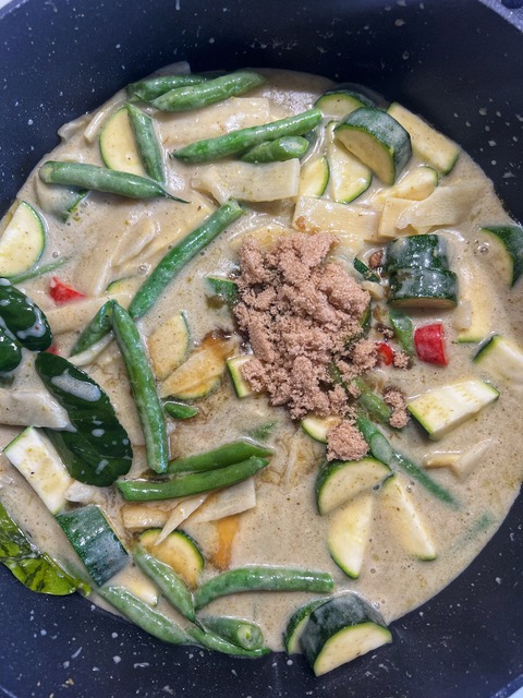 brown sugar and fish sauce add to green curry in a pan