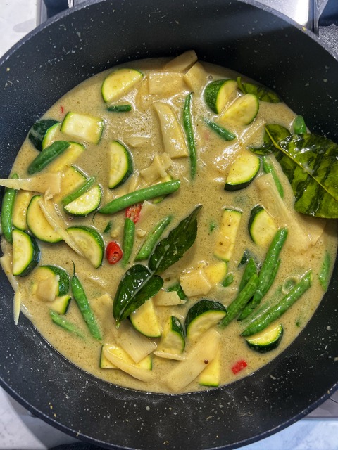 thai green curry sauce with vegetables cooking in a pan