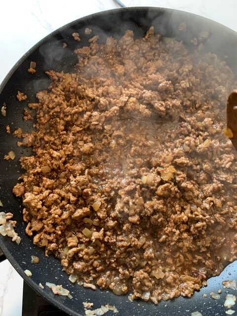 beef mince cooking in a pan with Asian sauce