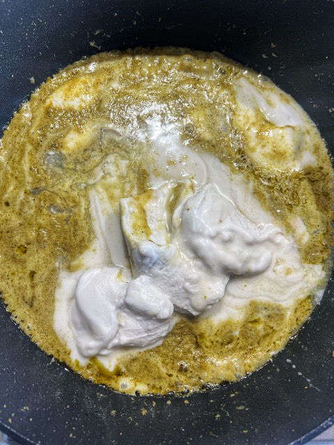 green curry paste and coconut cream cooking in a pan