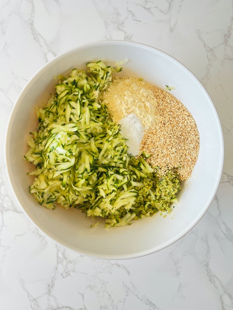 bowl with zucchini, and falafel mixture in it on white background