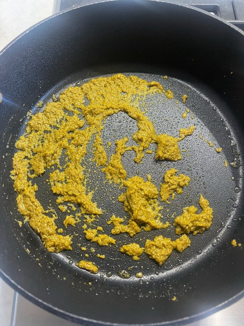 frying green curry paste in a pan