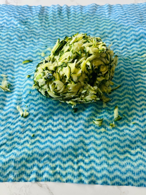wrung out grated zucchini on a cloth