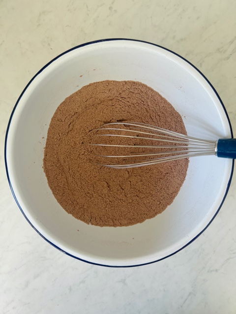 mixed dry ingredients for pancakes in a bowl with whisk