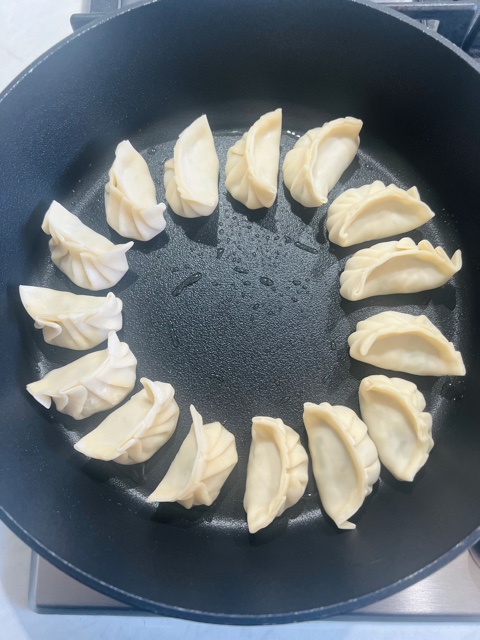 pork dumplings cooking in a pan