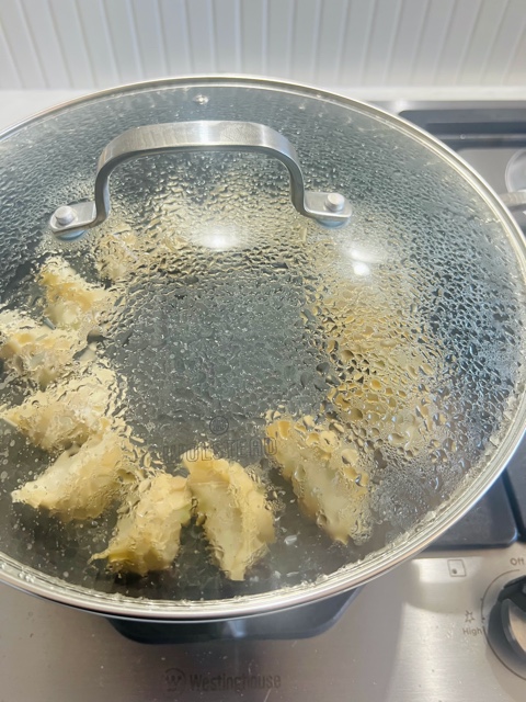 dumplings cooking with lid on