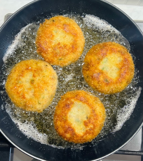 shallow frying salmon cakes turned over