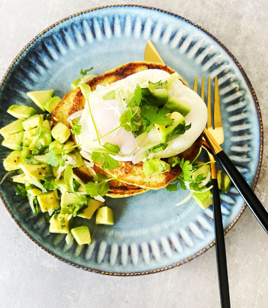 overhead of poached egg on corn fritters with salsa