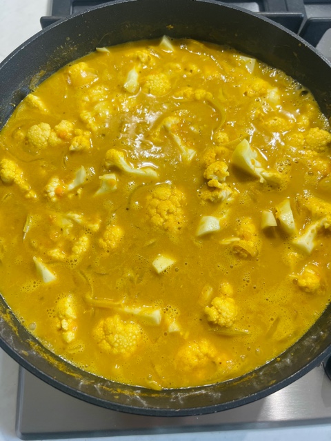 lentil and cauliflower curry cooking in a pan