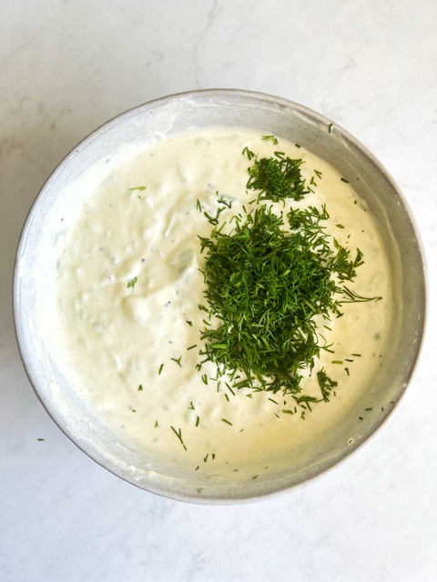 tzatziki dip in a bowl with chopped dill on top