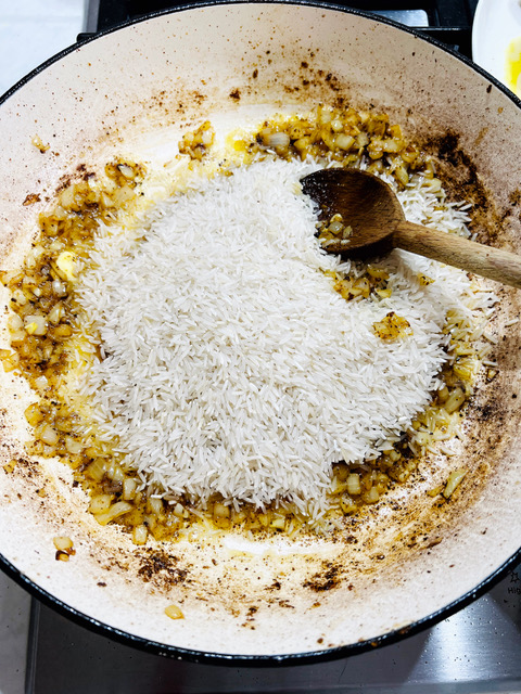 adding rice to pan with onions