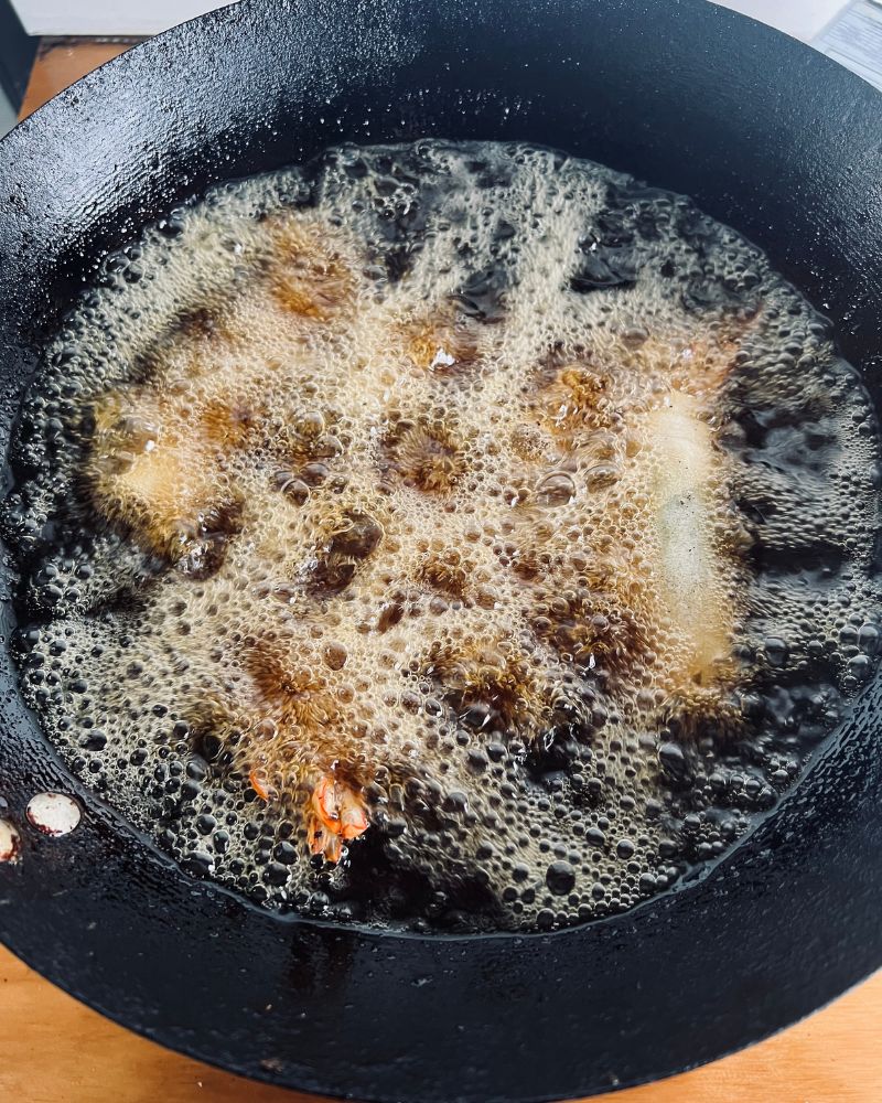 deep frying prawn spring rolls in a wok