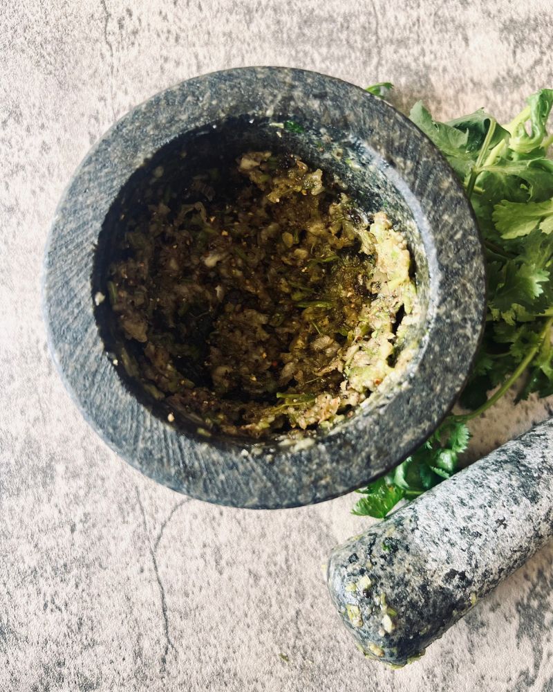 mortar and pestle with coriander paste inside