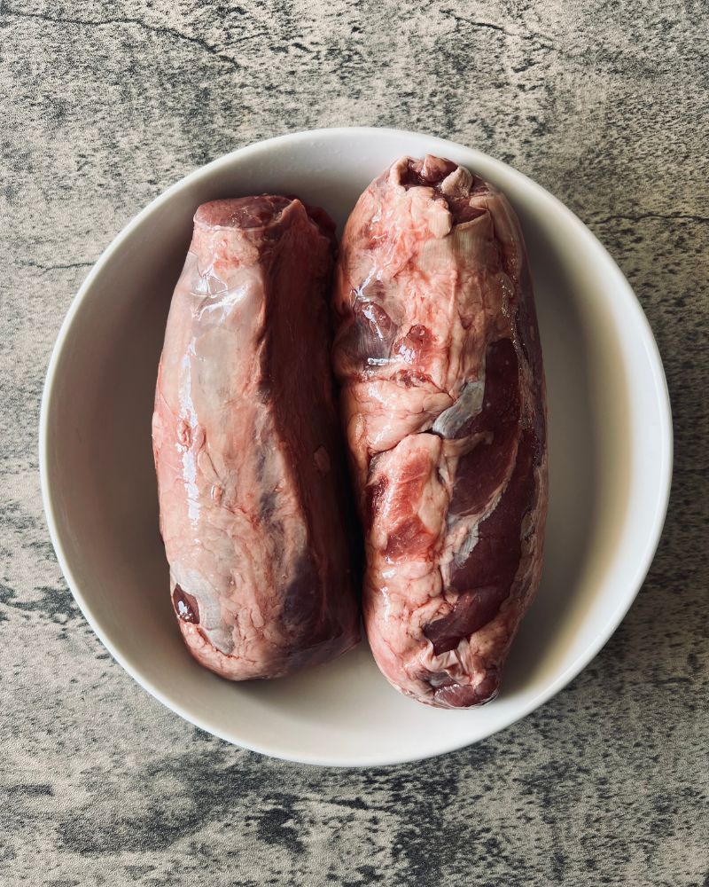 raw gravy beef whole shin in a white bowl on marble background