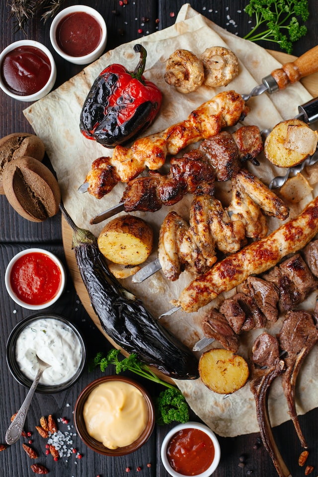 platter of grilled kebabs with sauces and dips around it