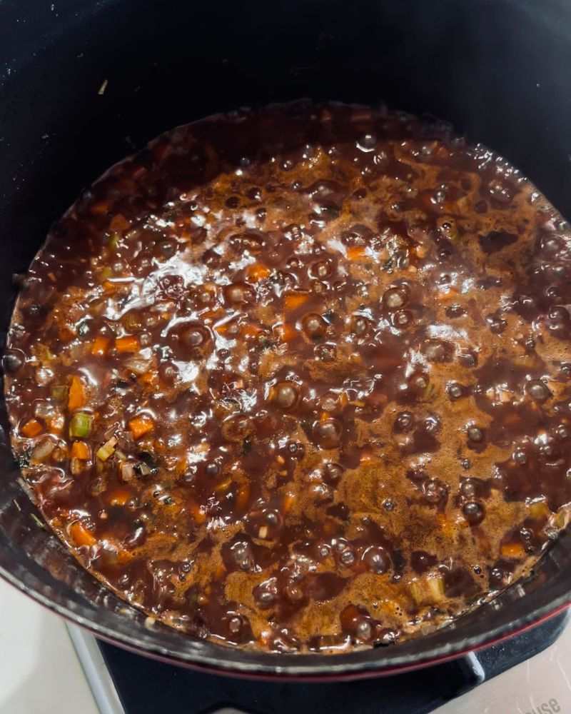 red wine and vegetables cooking in a pot