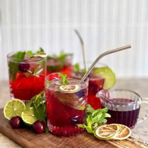 cocktails on a board with mint, limes and cherries